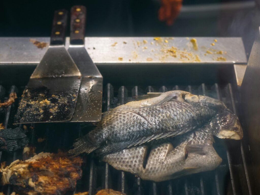 What Makes a Great Fish Fry? Top Picks & Flavor Secrets A whole tilapia fish grilling on an outdoor barbecue, capturing a smoky and savory experience.